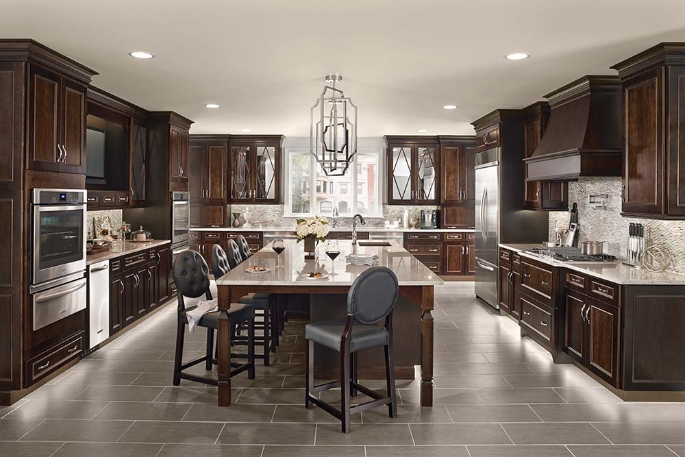 Custom kitchen with dark wood cabinets, light colored countertops and tile flooring