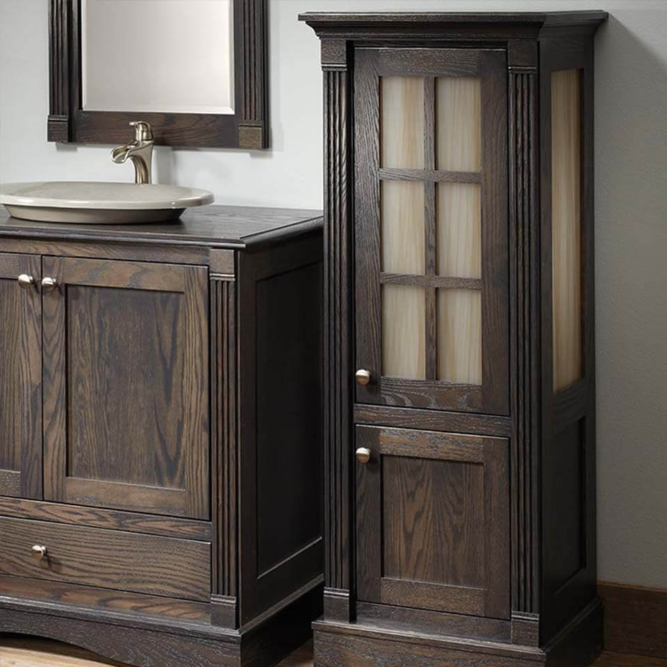 Dark wood free standing bathroom cabinet with frosted pane doors.