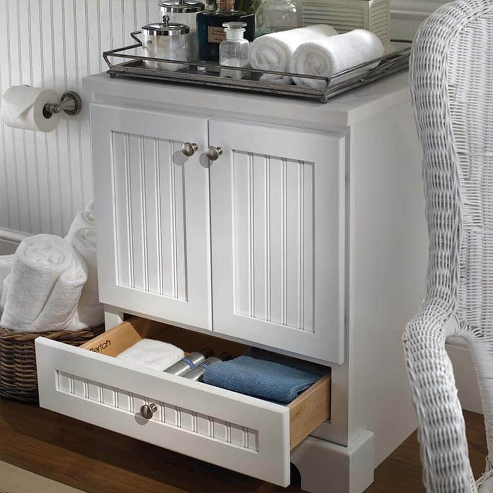 White bathroom cabinet with two doors and lower pull out drawer