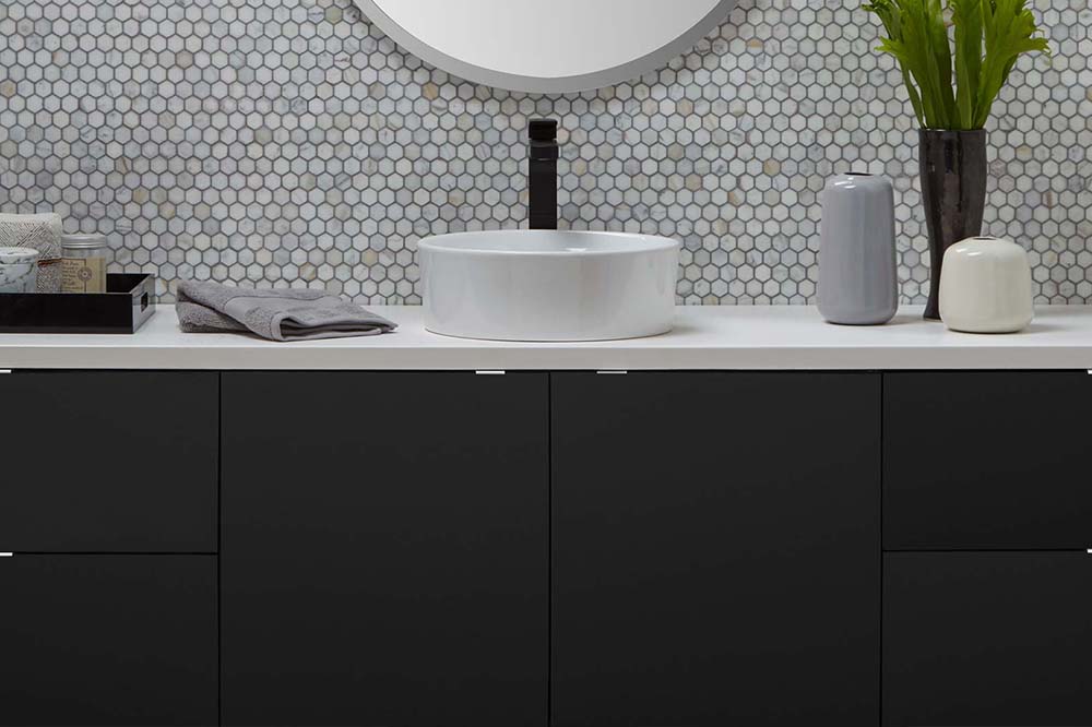 Modern black bathroom vanity with white counter and white bowl sink
