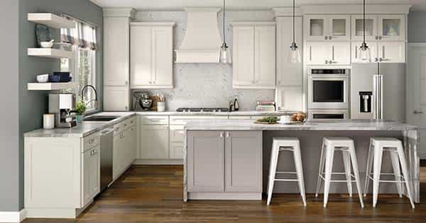 White kitchen cabinets and light grey kitchen island with seating for three