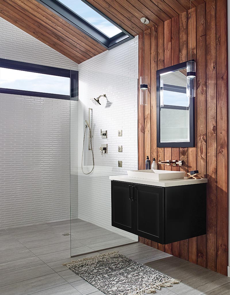 Farmhouse style bathroom with vertical wood paneling, large tile floors, frameless glass shower and floating black vanity