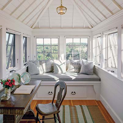 awning style windows in a sunroom, white room with built-in sofa, six awning windows open outward