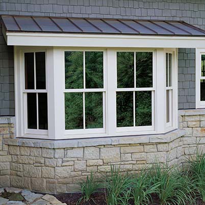 exterior view of white double-hung bay windows