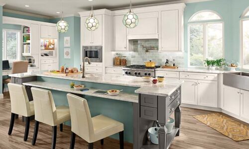 interior design photo of large kitchen with aqua walls and island, white cabinets, stainless appliances and farm sink, grey granite countertops, color matching light fixtures