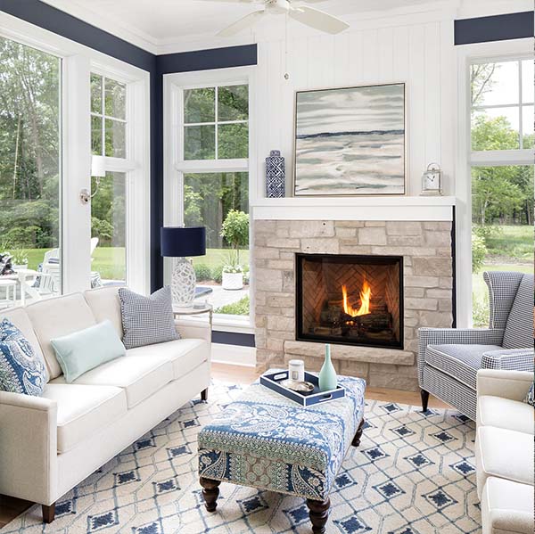 navy and white living room with full length white double hung windows, fireplace, living room furniture