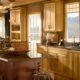 Large warm kitchen with honey oak cabinets and walnut island