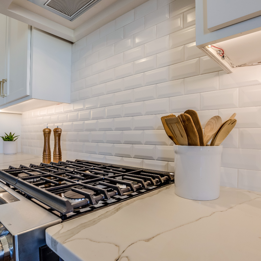 Kitchen backsplash in white beveled subway tile.